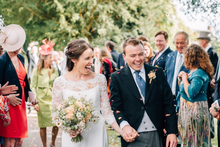 bride and groom walking through confetti after marrying