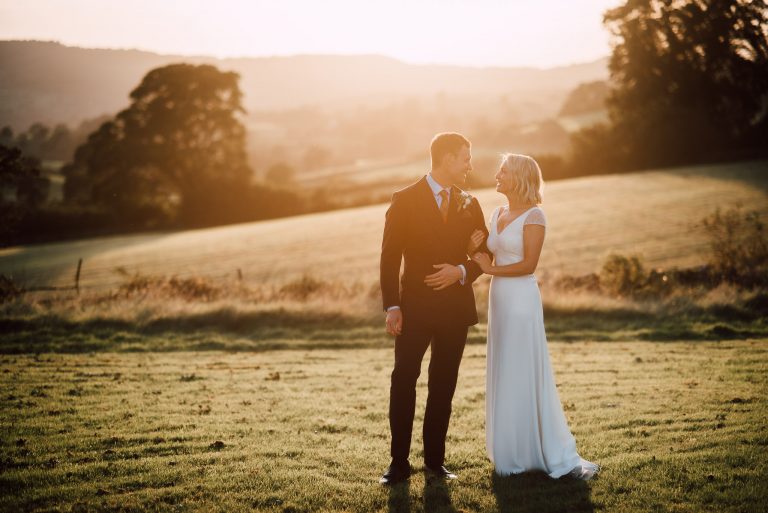bride and groom at sunset holding each other