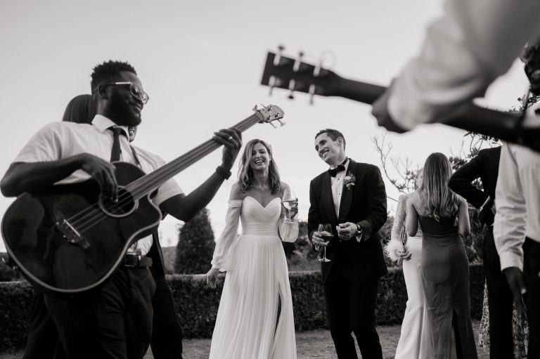 couple framed by musicians singing at their danesfield house wedding